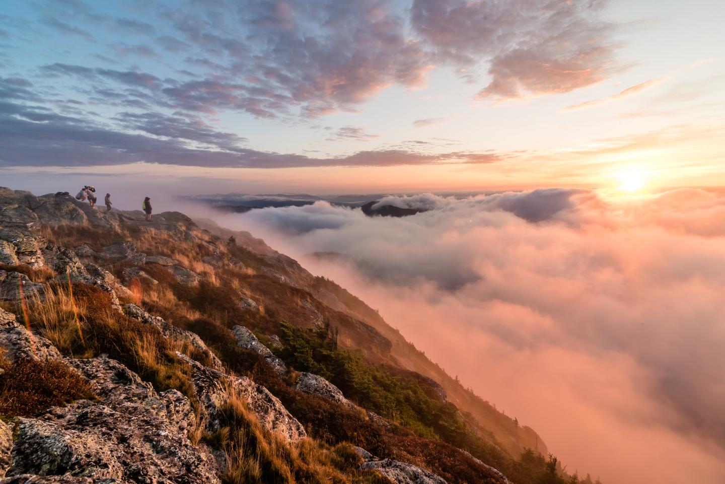 Mount Mansfield with sunset and clouds below the peaks.